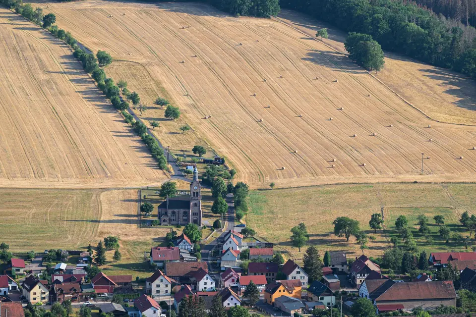 Malerische Luftaufnahme des Dorfs und Ackerlandes Hörselberg-Hainich, die eine Sommerlandschaft in Deutschland zeigt.